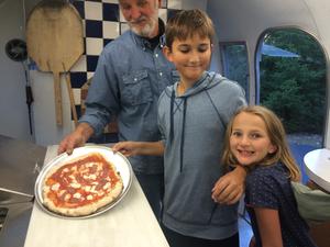 Anthony's creation fresh from the oven Photo of Darrold, Anthony and Celia in Airstream kitchen with Anthony's pizza