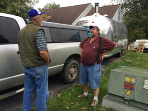 Darrold and Stephen talk hitches in the driveway before we hauled the trailer away. Photo of Darrold and Stephen in driveway beside trailer and pickup.